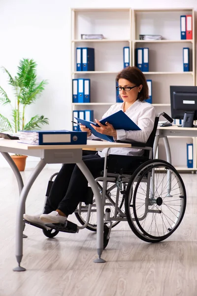 Employée en fauteuil roulant au bureau — Photo