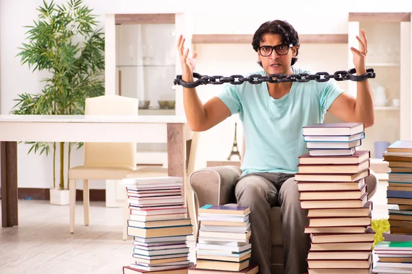 Estudiante masculino con muchos libros en casa —  Fotos de Stock