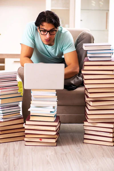 Estudante do sexo masculino com muitos livros em casa — Fotografia de Stock