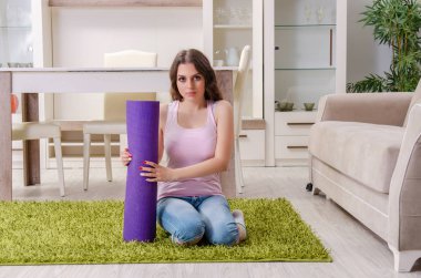 Genç güzel kadın evde egzersizleri yapıyor 