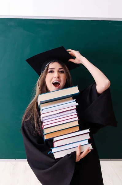 Female graduate student in front of green board — Stock Photo, Image