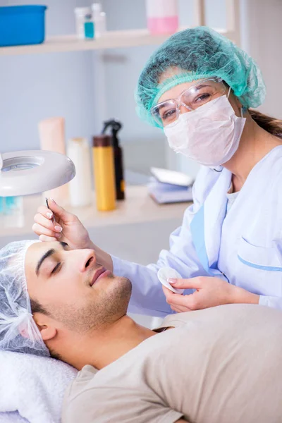 Giovane bell'uomo in visita medico cosmetologo femminile — Foto Stock