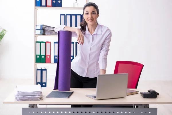 Giovane dipendente donna che fa esercizi in ufficio — Foto Stock