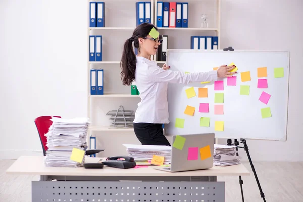 Joven empleada en el concepto de prioridades conflictivas — Foto de Stock