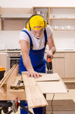 Mutfakta çalışan yaşlı bir tamirci. 