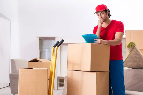 Joven contratista masculino con cajas trabajando en interiores — Foto de Stock