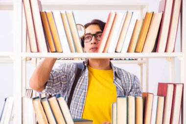 Erkek öğrenci kütüphanede sınava hazırlanıyor 