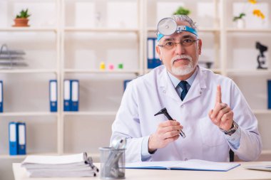 Klinikte çalışan yaşlı erkek doktor laryngologist 