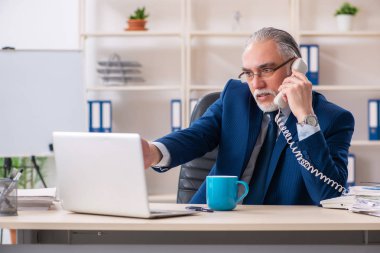 Ofiste çalışan yaşlı bir erkek işçi. 