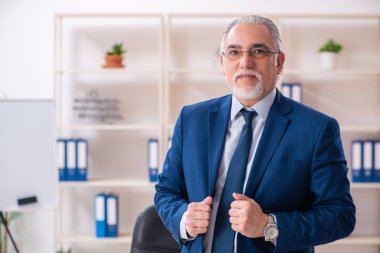 Ofiste çalışan yaşlı bir erkek işçi. 