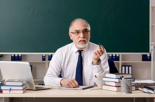 Leeftijd mannelijke leraar in de voorkant van schoolbord — Stockfoto