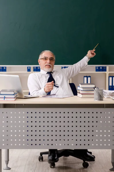 Leeftijd mannelijke leraar in de voorkant van schoolbord — Stockfoto