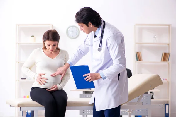 Vecchia donna incinta in visita giovane medico maschio — Foto Stock