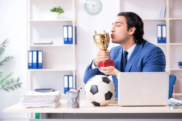 Молодий красивий бізнесмен з футбольним м'ячем в офісі — стокове фото