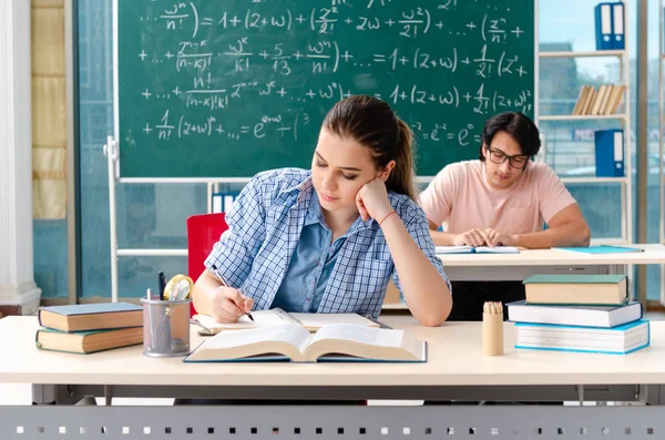 Jóvenes estudiantes tomando el examen de matemáticas en el aula — Foto de Stock