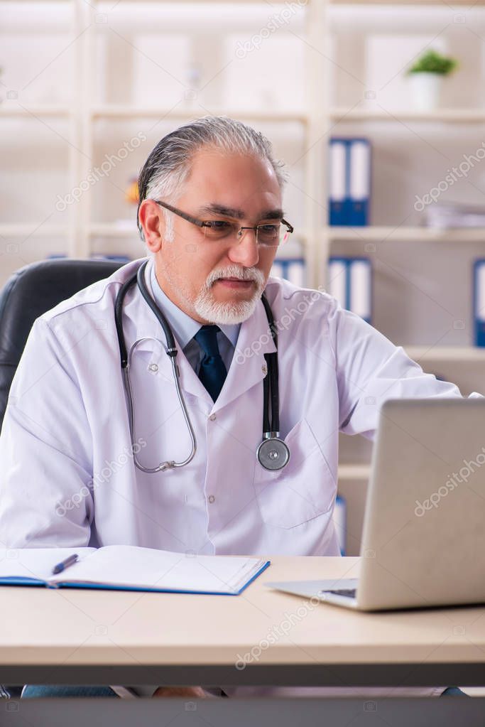 Aged male doctor working in the clinic 