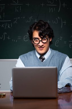 Kara tahta önünde genç matematik öğretmeni