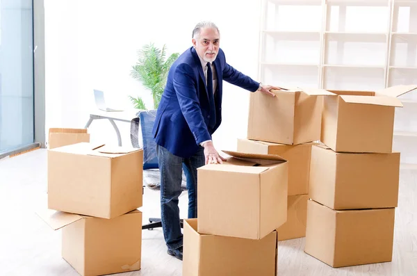 Betagter Geschäftsmann zieht an neuen Arbeitsplatz — Stockfoto