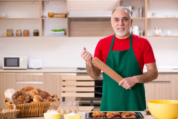 Viejo panadero trabajando en la cocina — Foto de Stock