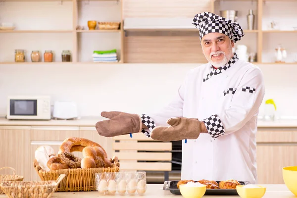 Viejo panadero trabajando en la cocina — Foto de Stock