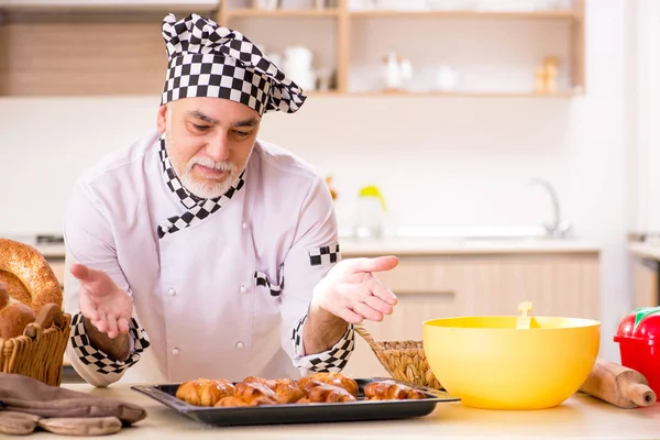 Starý muž baker práci v kuchyni — Stock fotografie