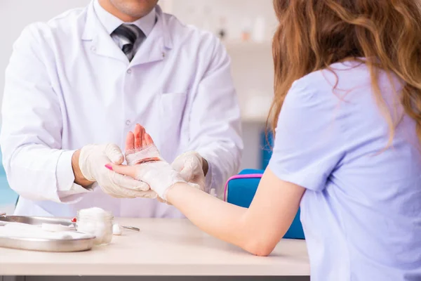 Рука поранена жінка, яка відвідує лікаря травматолога — стокове фото