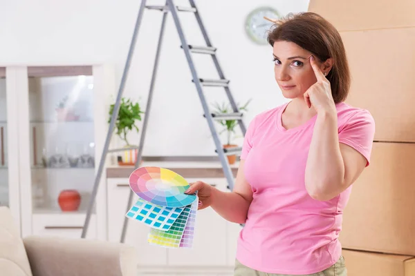 Frau wählt Farbe für flache Erneuerung — Stockfoto