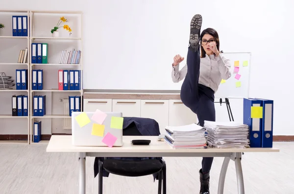 Giovane impiegata che fa esercizi sul posto di lavoro — Foto Stock