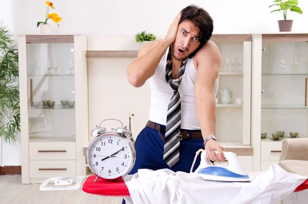 Hombre joven planchando en el dormitorio — Foto de Stock