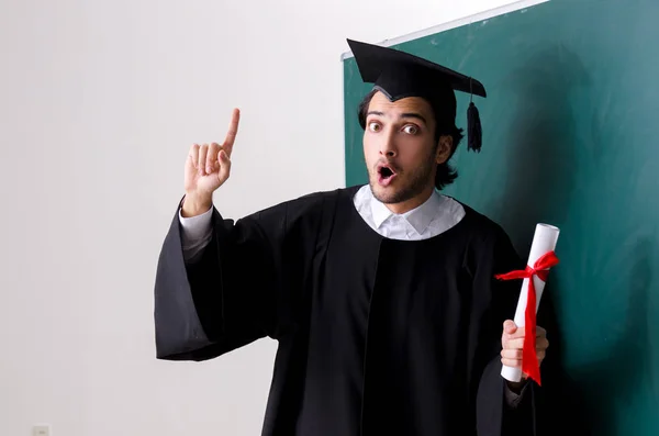 Étudiant diplômé devant le tableau vert — Photo
