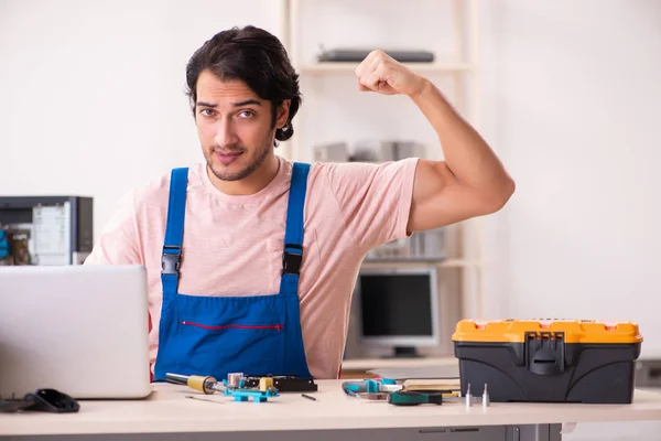 Jovem empreiteiro do sexo masculino reparando computador — Fotografia de Stock