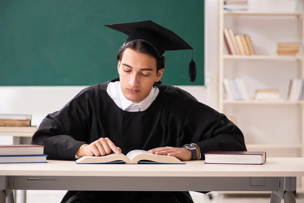 Graduate student in front of green board — Stock Photo, Image