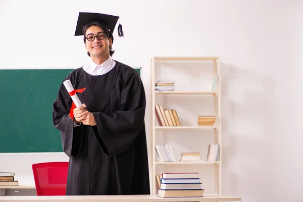 Estudante graduado na frente do quadro verde — Fotografia de Stock