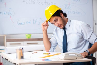 Genç erkek mimar beyaz tahtanın önünde. 