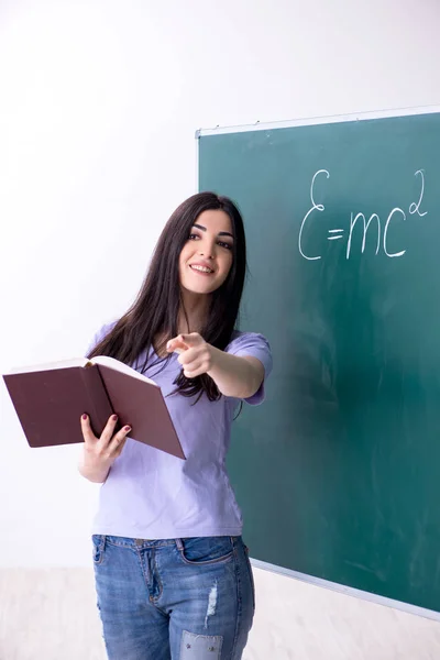 Νεαρή μαθήτρια δασκάλα μπροστά από το πράσινο πίνακα — Φωτογραφία Αρχείου