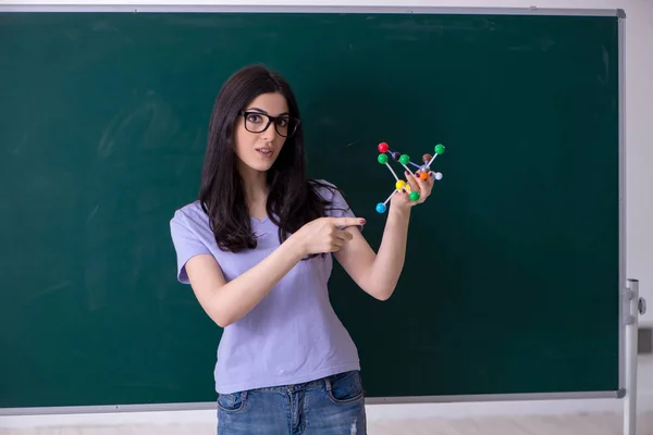 Jovem estudante professora na frente do quadro verde — Fotografia de Stock