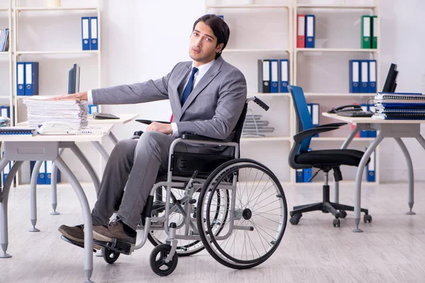 Młody przystojny pracownik na wózku inwalidzkim pracujący w biurze — Zdjęcie stockowe