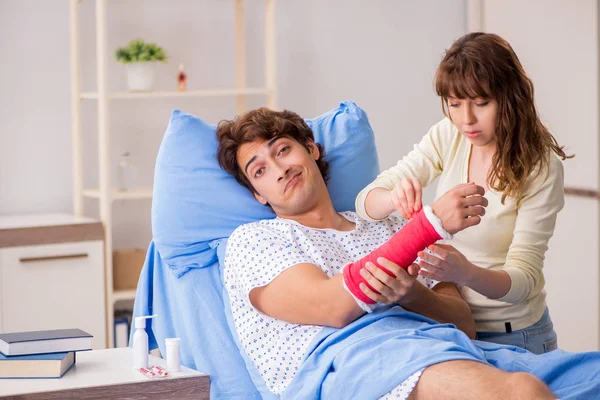 Liebevolle Ehefrau kümmert sich im Krankenhaus um verletzten Ehemann — Stockfoto