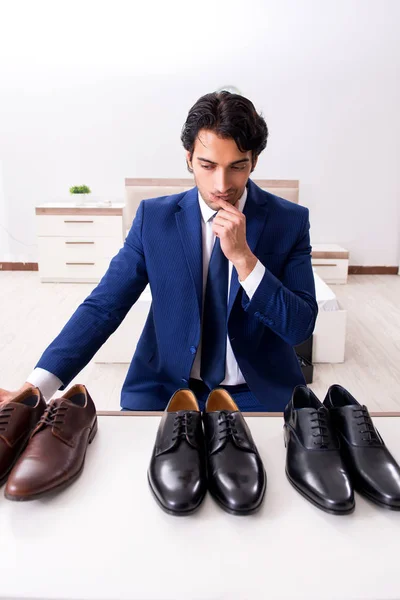 Young handsome businessman choosing shoes at home — Stock Photo, Image