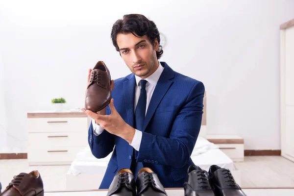 Ung snygg affärsman att välja skor hemma — Stockfoto