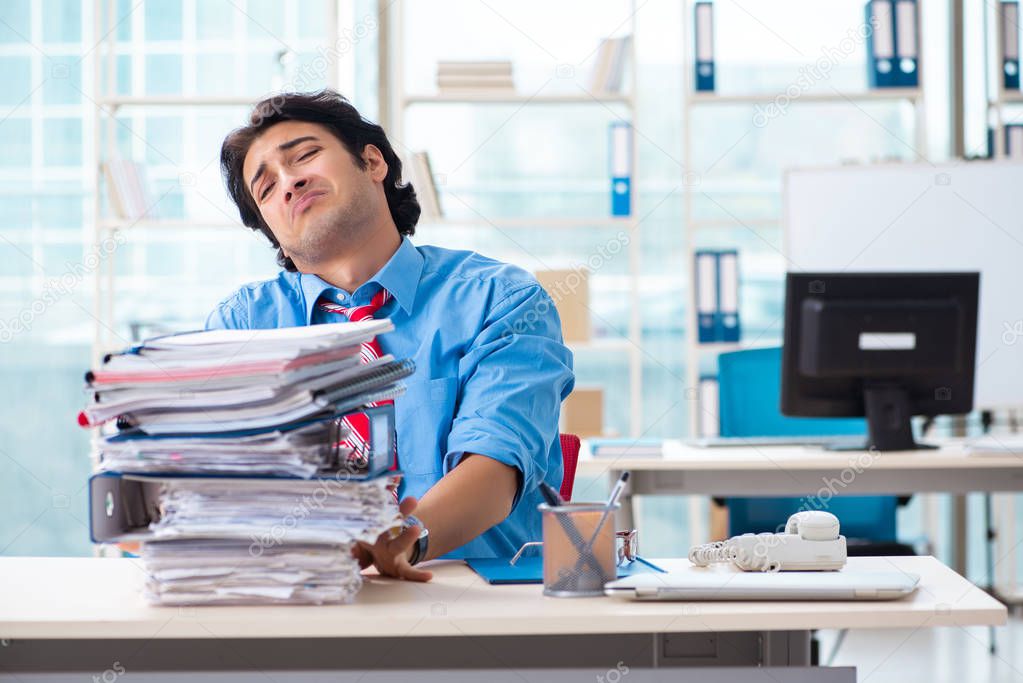 Handsome businessman unhappy with excessive work in the office 