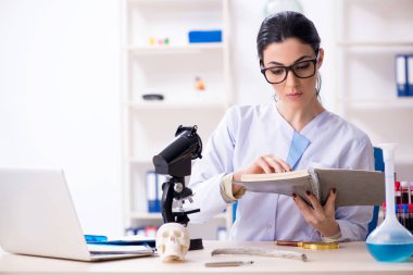 Laboratuvarda çalışan genç bir kadın arkeolog. 