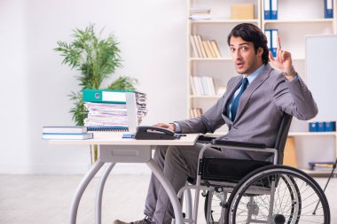 Genç yakışıklı çalışan tekerlekli sandalyeye mahkum ofiste 