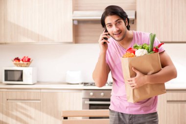 Yakışıklı delikanlı mutfakta sebze ile 