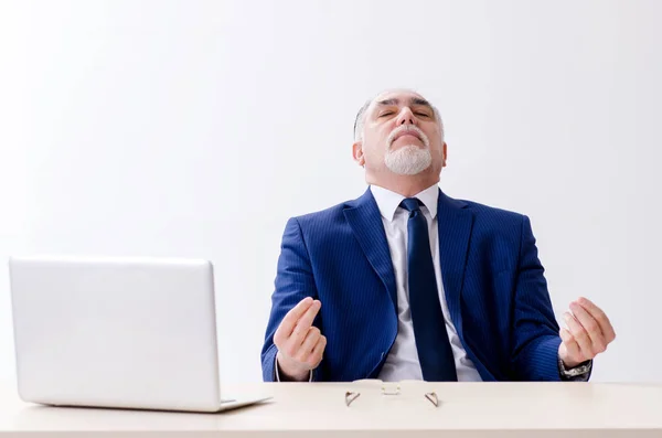 Homem de negócios envelhecido fazendo exercícios de ioga no escritório — Fotografia de Stock