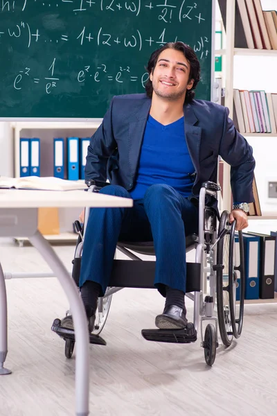 Jonge knappe man in rolstoel voorkant schoolbord — Stockfoto