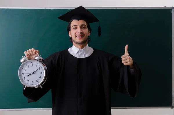 Estudante graduado na frente do quadro verde — Fotografia de Stock