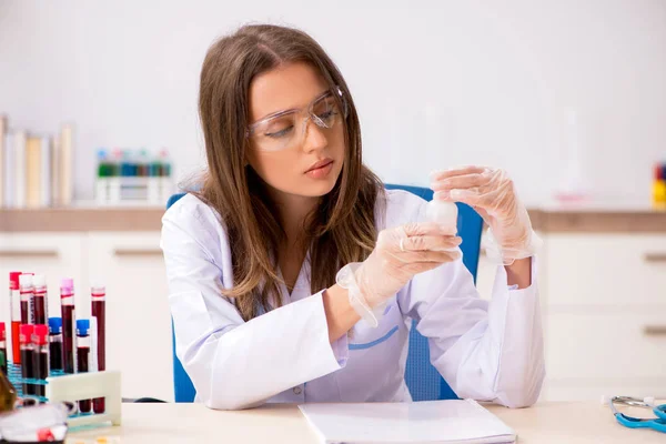 Joven hermosa asistente de laboratorio de análisis de muestras de sangre — Foto de Stock