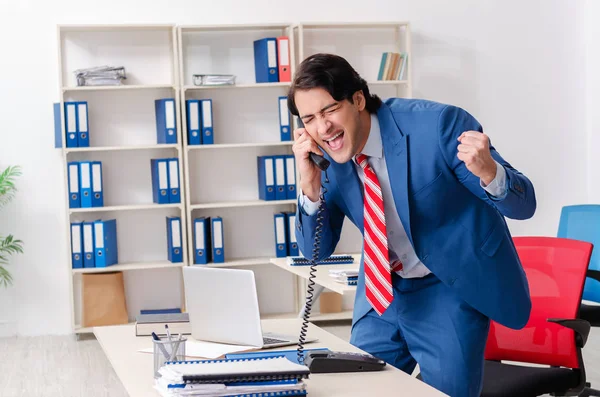 Junge glückliche männliche Angestellte im Büro — Stockfoto