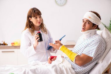 Genç doktor yaralı hastayı muayene ediyor. 